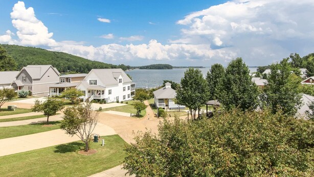 A residential area with houses, a lake, and a hilly landscape. - House# 30 Endless View Not Pet-Friendly (Leesburg)