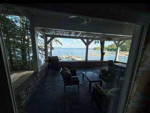 An outdoor patio with a view of a body of water, wooden furniture, and a pergola structure. - House #41 Moonset Vista House (Leesburg)