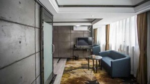 A modern hotel room with a large window, a flat-screen TV, a sofa, and a small table. - Zhangjiajie Mr.F Boutique Hotel (Tianmen Mountain Cableway Station) (Zhangjiajie)