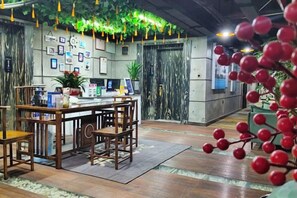 A reception area with a wooden desk, chairs, and a plant. - Zhangjiajie Mr.F Boutique Hotel (Tianmen Mountain Cableway Station) (Zhangjiajie)