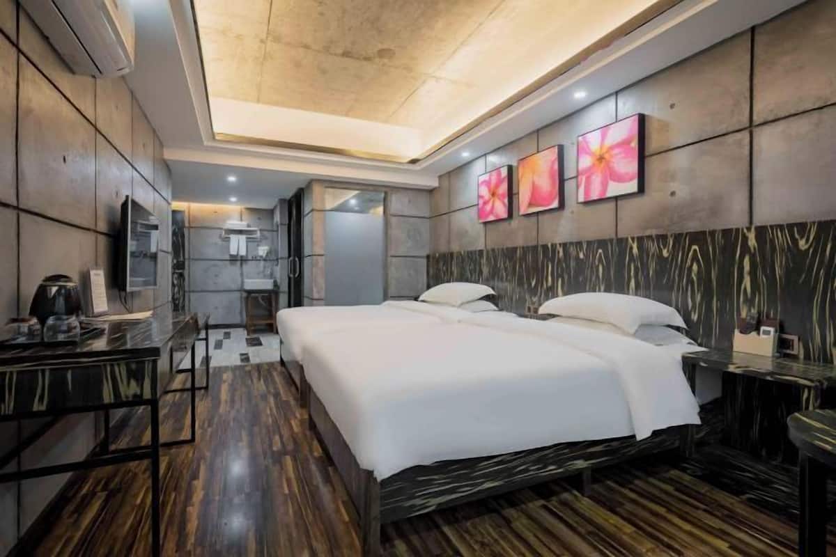A modern hotel room with a large bed, a desk, and a vanity.