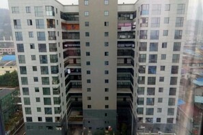 Un immeuble résidentiel à plusieurs étages, doté de balcons et d’une cour intérieure.