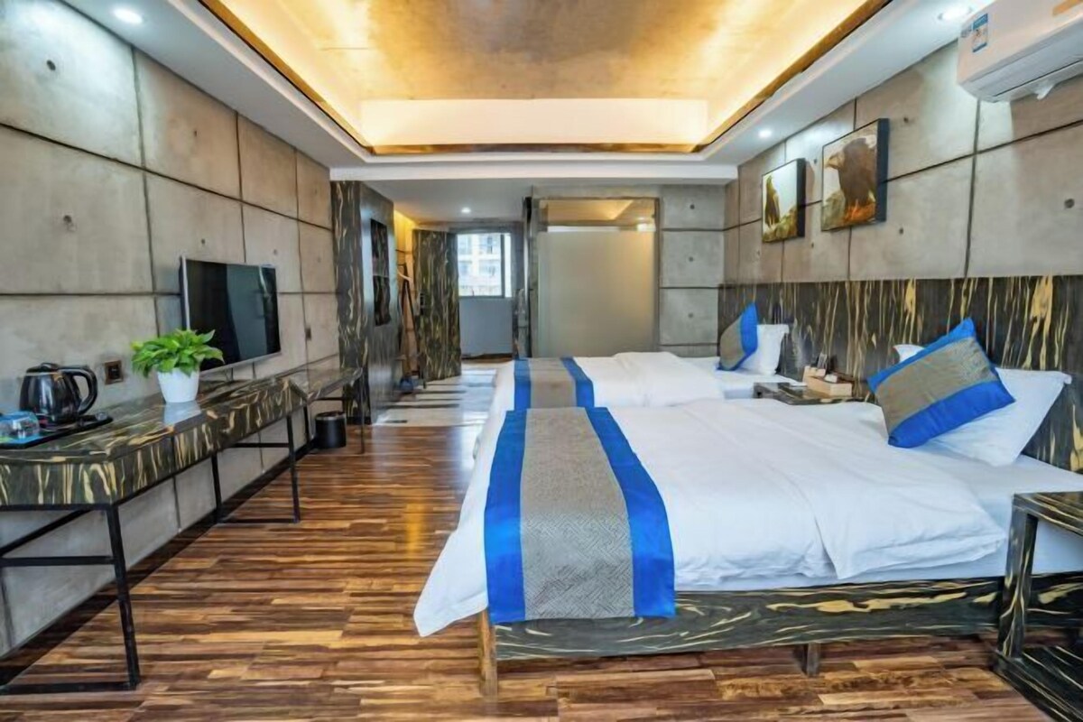 Une chambre d’hôtel avec un grand lit, des tables de chevet, une télévision et une plante.