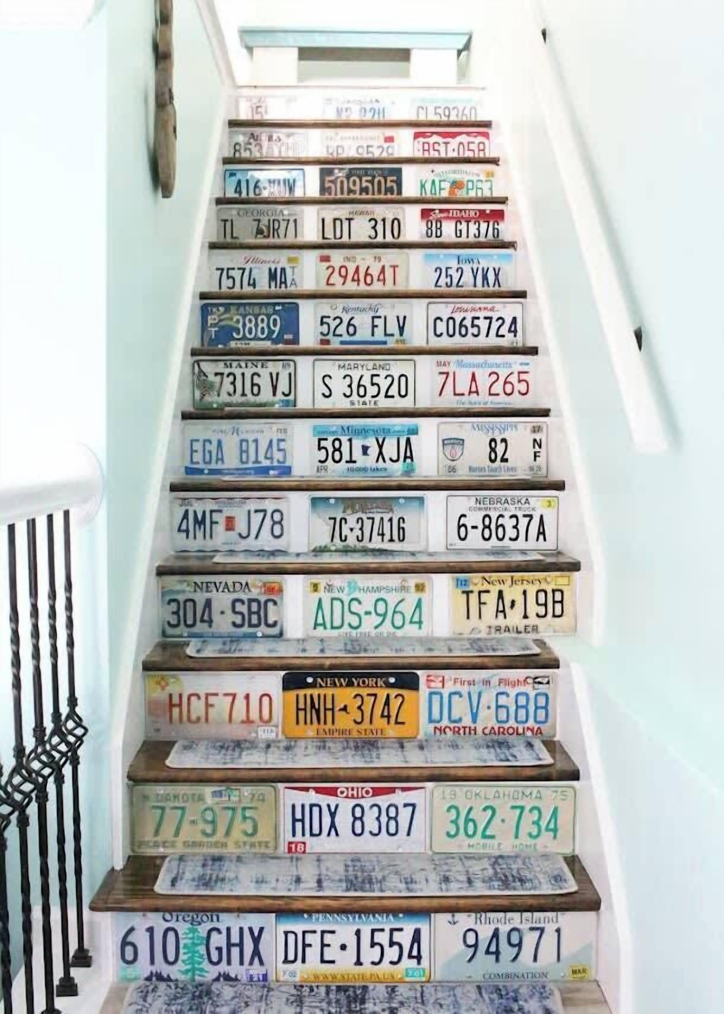 A collection of license plates from various U.S. states arranged on a staircase.