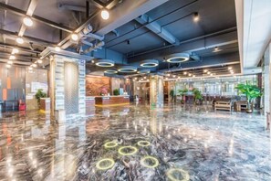 A spacious lobby with a polished marble floor, circular light fixtures, and a reception desk. - Rimei Hotel (Foshan Sanshui New Power) (Foshan)