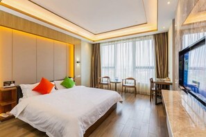 A hotel room with a large bed, a desk, and a TV. - Rimei Hotel (Foshan Sanshui New Power) (Foshan)