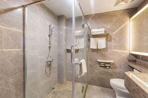 A modern bathroom with a glass-enclosed shower, a toilet, and a vanity with a mirror. - Rimei Hotel (Foshan Sanshui New Power) (Foshan)