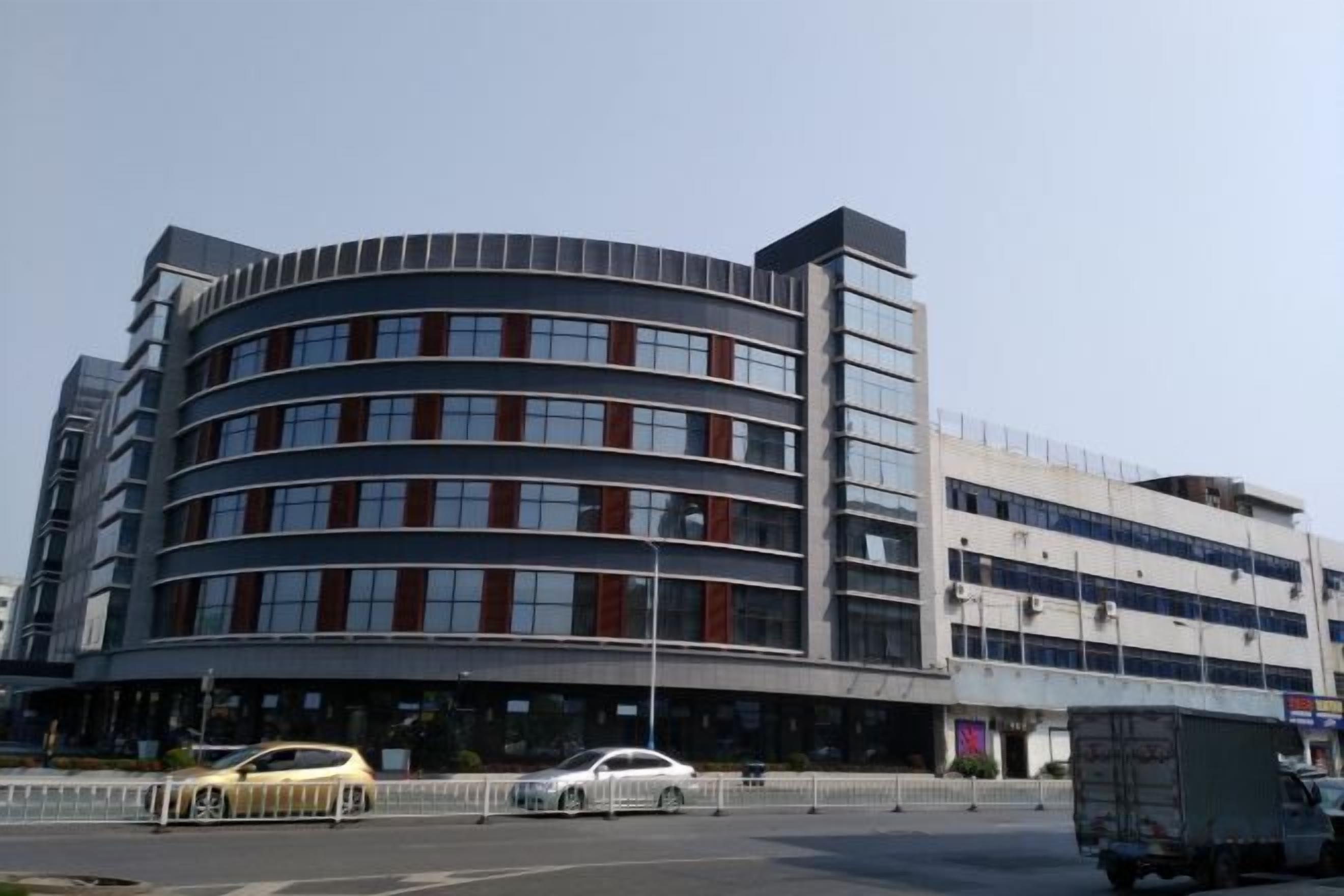 Un immeuble à plusieurs étages doté d’une façade incurvée, de grandes fenêtres et d’un toit plat.