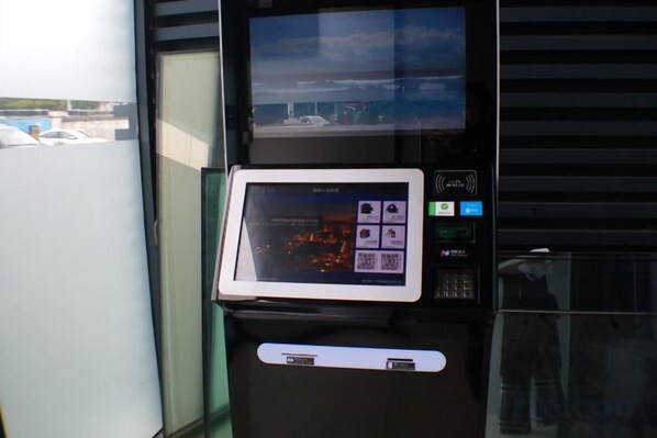 Quiosco de autoservicio con pantalla táctil, una pantalla pequeña en la parte superior y un lector de tarjetas debajo.