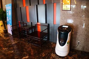 A seating area with chairs and a coffee machine. - Rimei Hotel (Foshan Sanshui New Power) (Foshan)