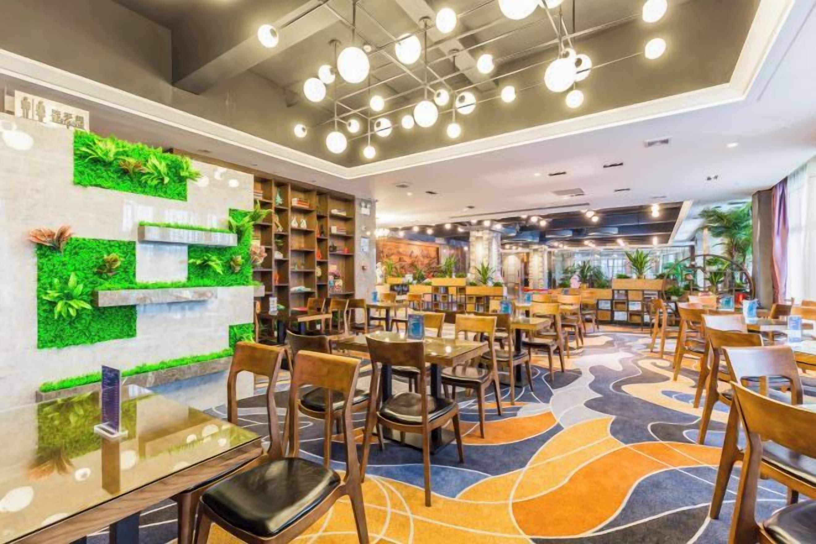 A modern library with bookshelves, tables, and chairs arranged for reading and dining.