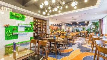 A modern library with bookshelves, tables, and chairs arranged for reading and dining.
