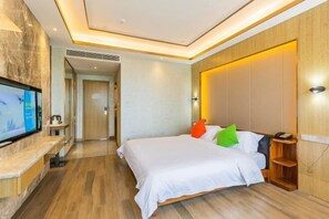 A modern hotel room with a large bed, a television on a marble countertop, and a wooden headboard. - Rimei Hotel (Foshan Sanshui New Power) (Foshan)