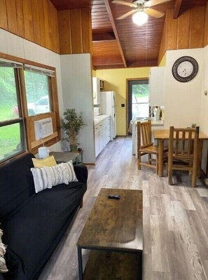Relax in this compact living space with a sofa, dining area, and kitchen view.