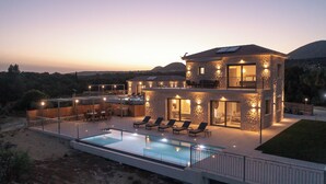 Ein modernes, zweist öckiges Haus mit Pool, Außenbereich und einer Steinfassade.
