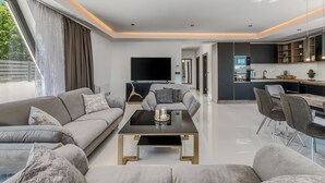 Una sala de estar moderna con sofá, mesa de centro y televisor.