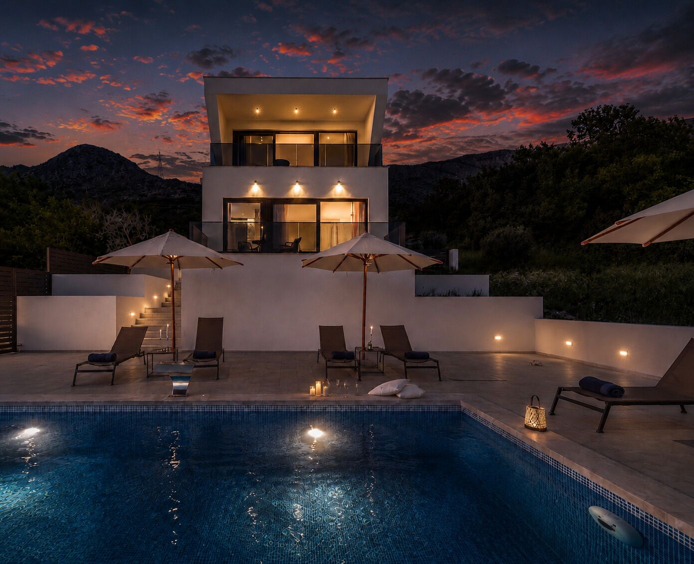 A modern house with a pool, outdoor seating, and a staircase leading to a balcony.