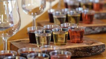 A bar setting with multiple glasses and shot glasses arranged on wooden coasters.