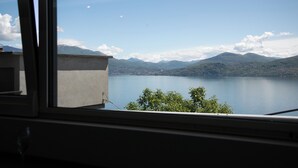 A view of a lake with mountains in the background through a window.