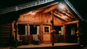 Une cabane en bois avec un porche, une porte en bois et une enseigne indiquant qu’il s’agit d’un « Bunker Lodge ».