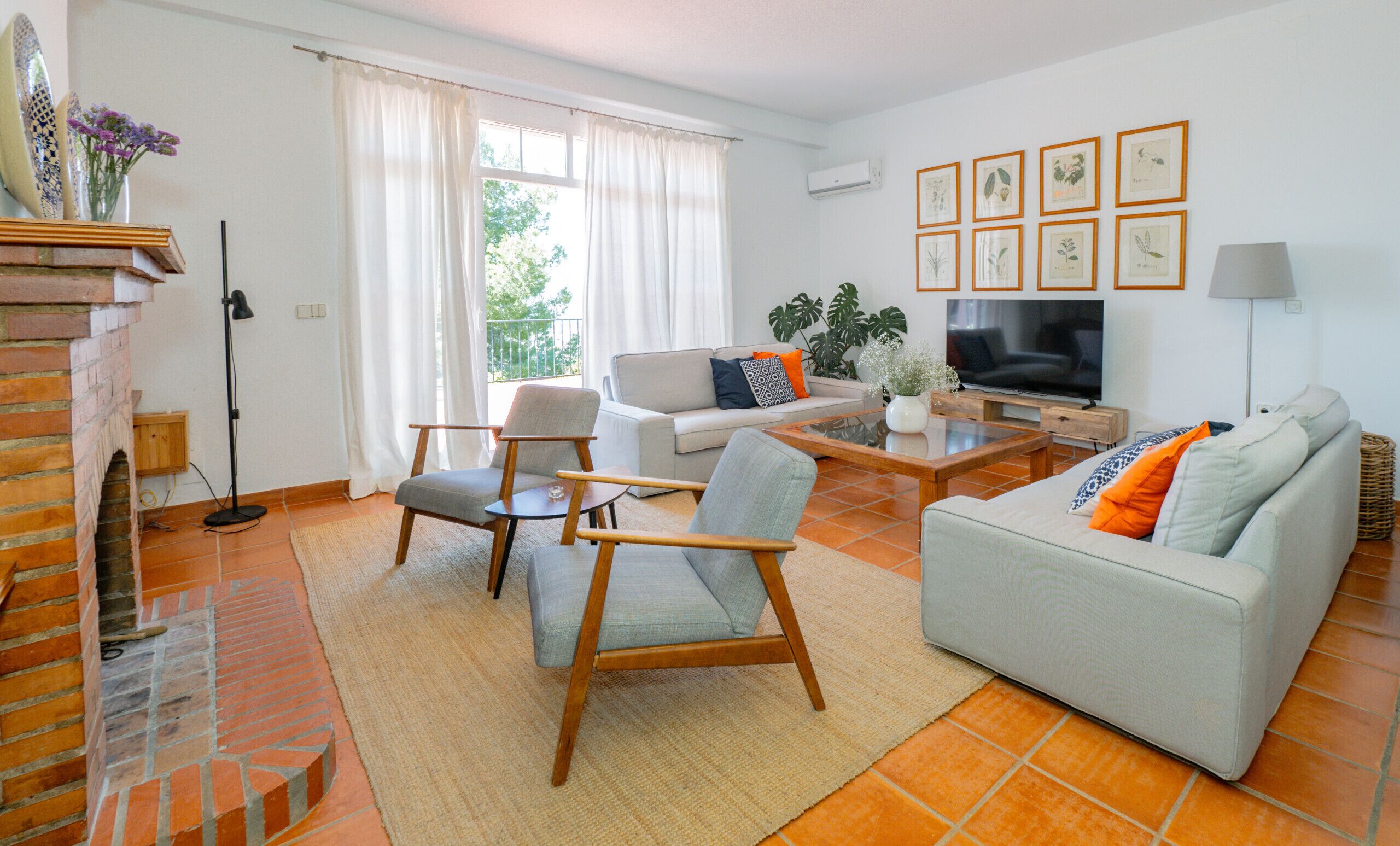 Een woonkamer met een open haard, een bank, een salontafel en een televisie.