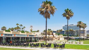 Un restaurante llamado 'mana' con terraza y palmeras.
