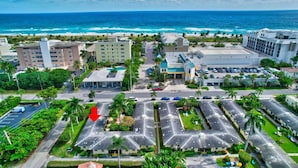 An aerial view of a coastal hotel with multiple buildings, parking lots, and a view of the ocean. - Beach Bungalow  (Delray Beach)