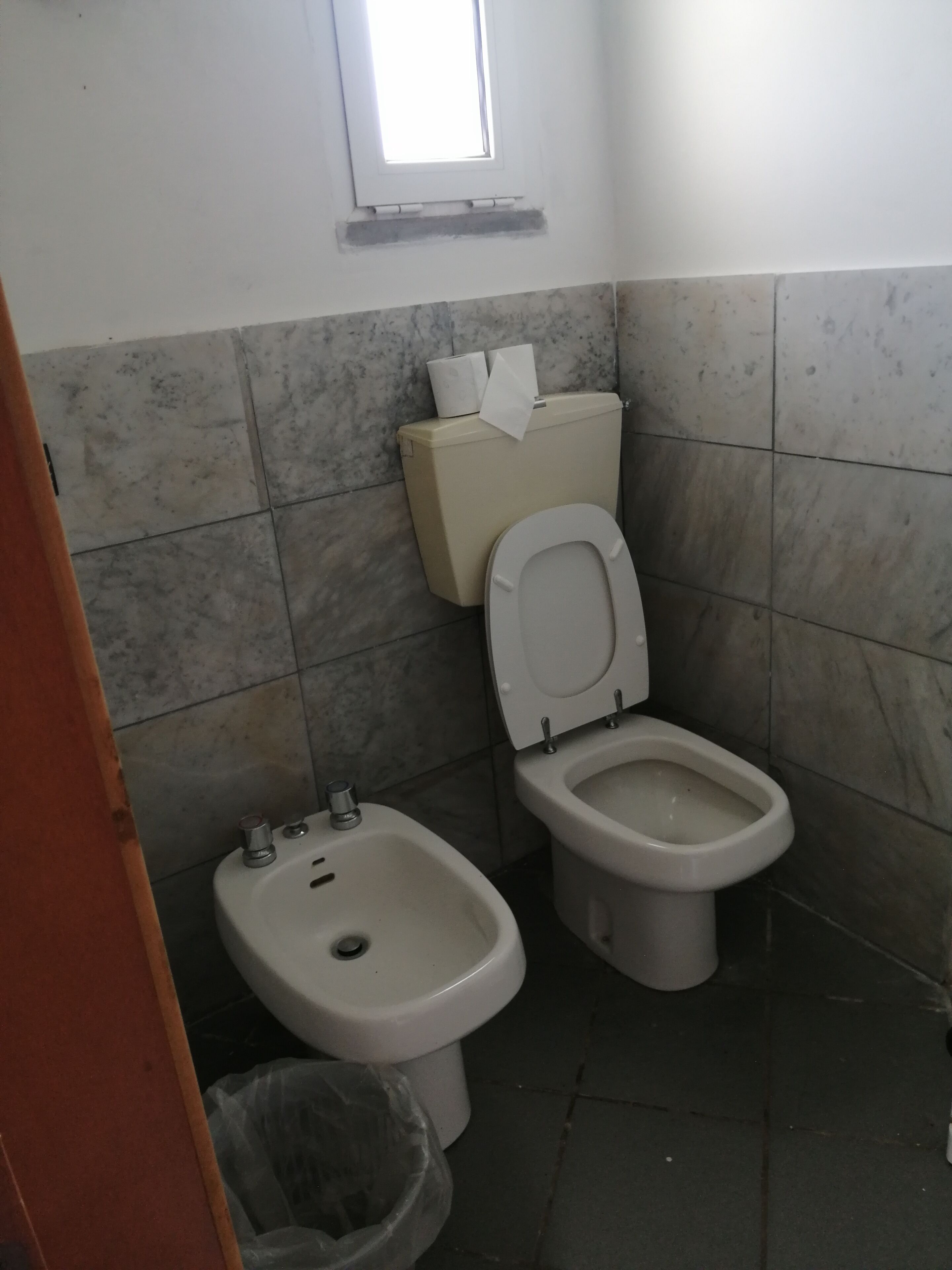 Un baño con inodoro, bidé y lavamanos pequeño.