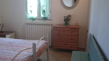 A bedroom with a bed, a dresser, a mirror, and a bench.