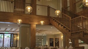 A spacious dining area with wooden tables and chairs, a staircase, and hanging spherical light fixtures. - Termales Santa Rosa de Cabal - Hotel  (Santa Rosa de Cabal)