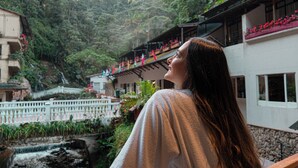 A person overlooking a mountainous area with a building that has balconies with red flowers. - Termales Santa Rosa de Cabal - Hotel  (Santa Rosa de Cabal)