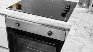 A kitchen with a built-in stove, oven, and a marble countertop. - Luxury 2 Bed Apartment - Smart TV - WIFI -  Jewellery Quarter (Birmingham)