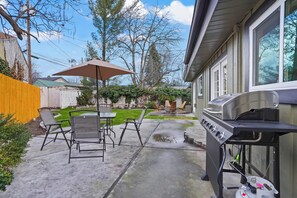 A backyard patio with a grill, outdoor furniture, and a lawn. - Yard w/ fire pit & grill, king bed, light filled (Boise)