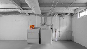 Una habitación con un calentador de agua de estilo industrial, un sistema de filtración de agua y una tubería de agua.