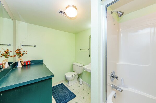 Un baño con inodoro, lavamanos y ducha.