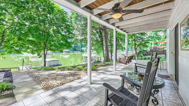 A covered patio with a view of a lake, outdoor seating, and a ceiling fan. - Locke Haven (Sherrills Ford)