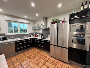 A modern kitchen with stainless steel appliances, a window, and a tiled floor. - Character House with 3000 m² Garden, Alabaster Coast (Sauqueville)