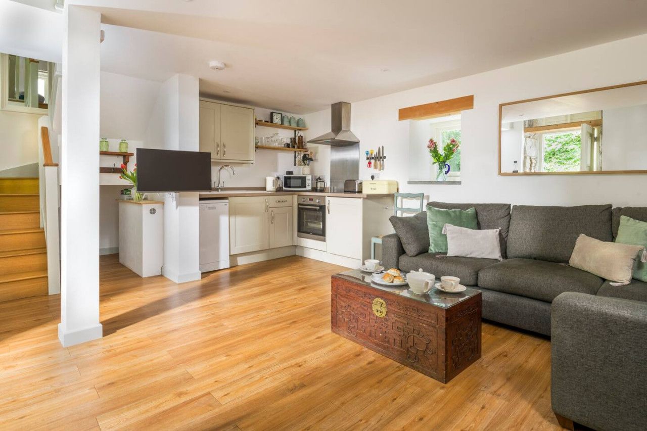 A modern living room with a grey sofa, a coffee table, and a TV.