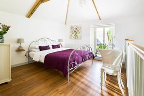 Ein Schlafzimmer mit Bett, Stuhl, Fenster und Heizkörper.
