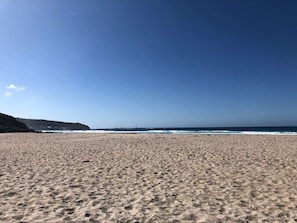 A beach with a clear sky and ocean in the background.