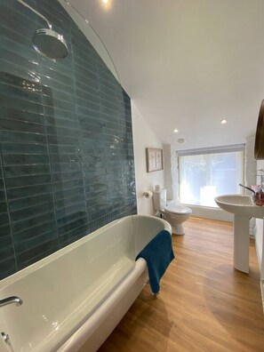 A modern bathroom with a freestanding bathtub, a toilet, and a sink.