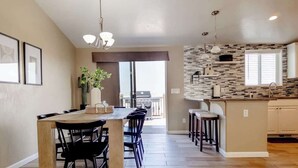 Une cuisine spacieuse avec un coin repas, un pare-feu en pierre et une vue sur l  ’extérieur.