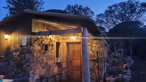 A rustic stone building with a wooden door and a bench outside. - Location Corsica, T2 800 m from Cala Rossa Beach (Lecci)