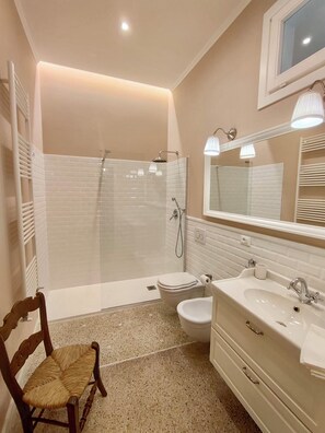 A modern bathroom with a shower, toilet, and vanity.