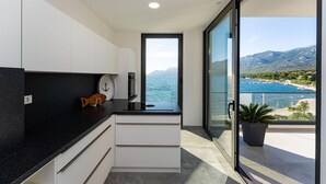 Eine moderne Küche mit Blick auf Meer und Berge.