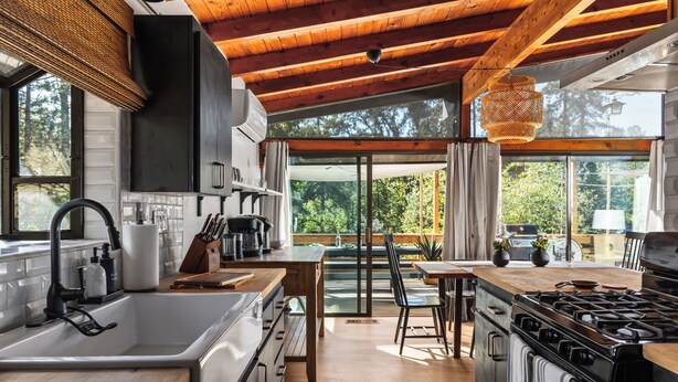 A modern kitchen with wooden beams, a large island, and a view of the outdoors. - Family Cabin, Dog, Ht Tb, 15 min Yosemite, Valentine's Day + Firefall Packages (Oakhurst)