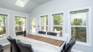 A dining room with a large table, six chairs, and a skylight. - Ocean Pines 3BR House Resort Community (Berlin)