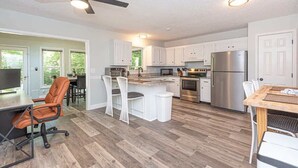 A modern kitchen with white cabinets, a central island, stainless steel appliances, and a ceiling fan. - Ocean Pines 3BR House Resort Community (Berlin)