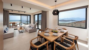 Un salon moderne avec un coin repas, de grandes fenêtres et une vue sur le paysage.