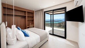 Une chambre avec un lit, une télévision, une armoire et un balcon offrant une vue.